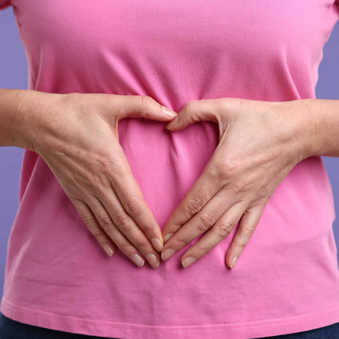 Person forming a heart shape over their stomach, symbolizing prebiotic fibre gut health support.
