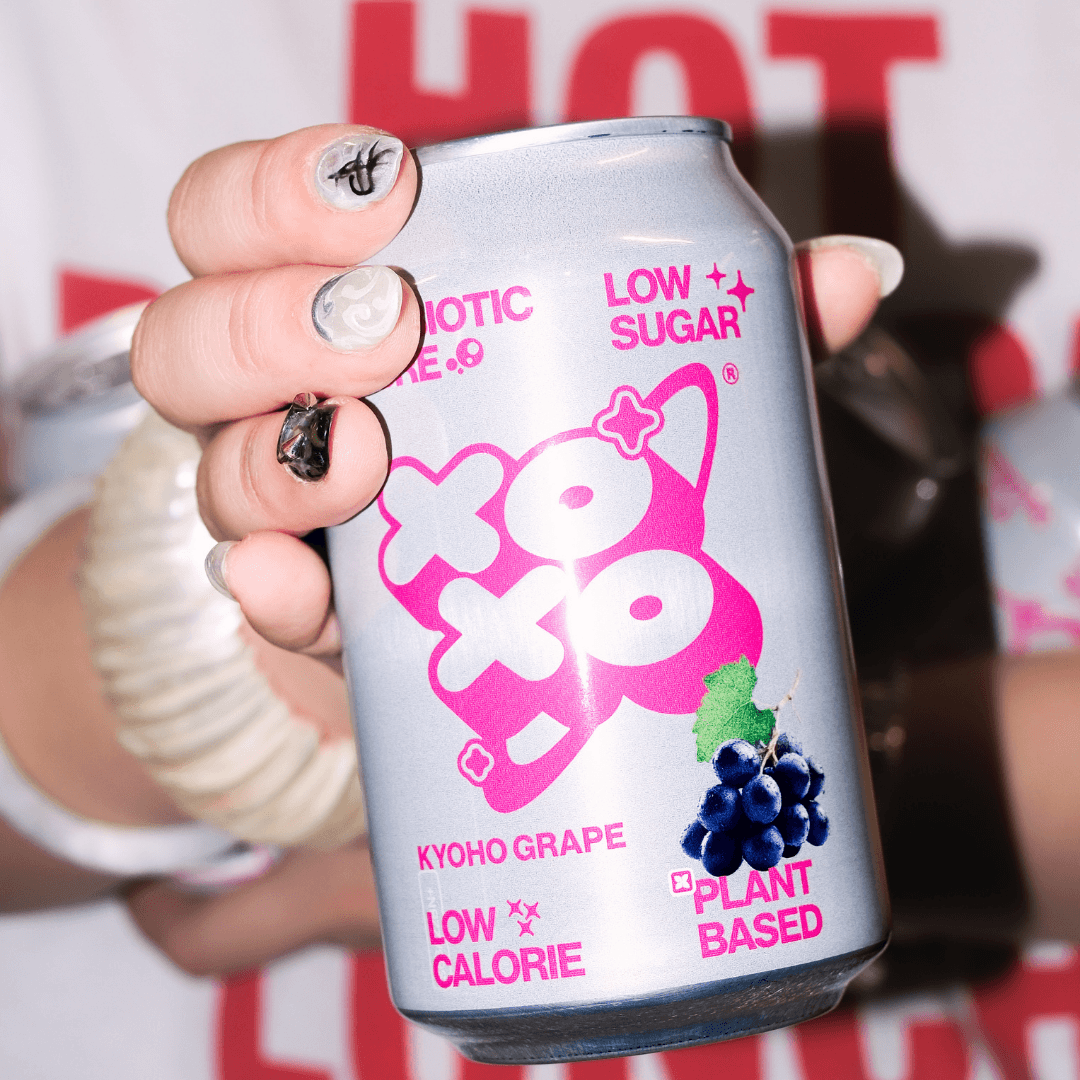 Kyoho Grape Prebiotic Soda | XOXO Limited Edition - 12 Pack shown in hand, featuring low sugar and low calorie details.
