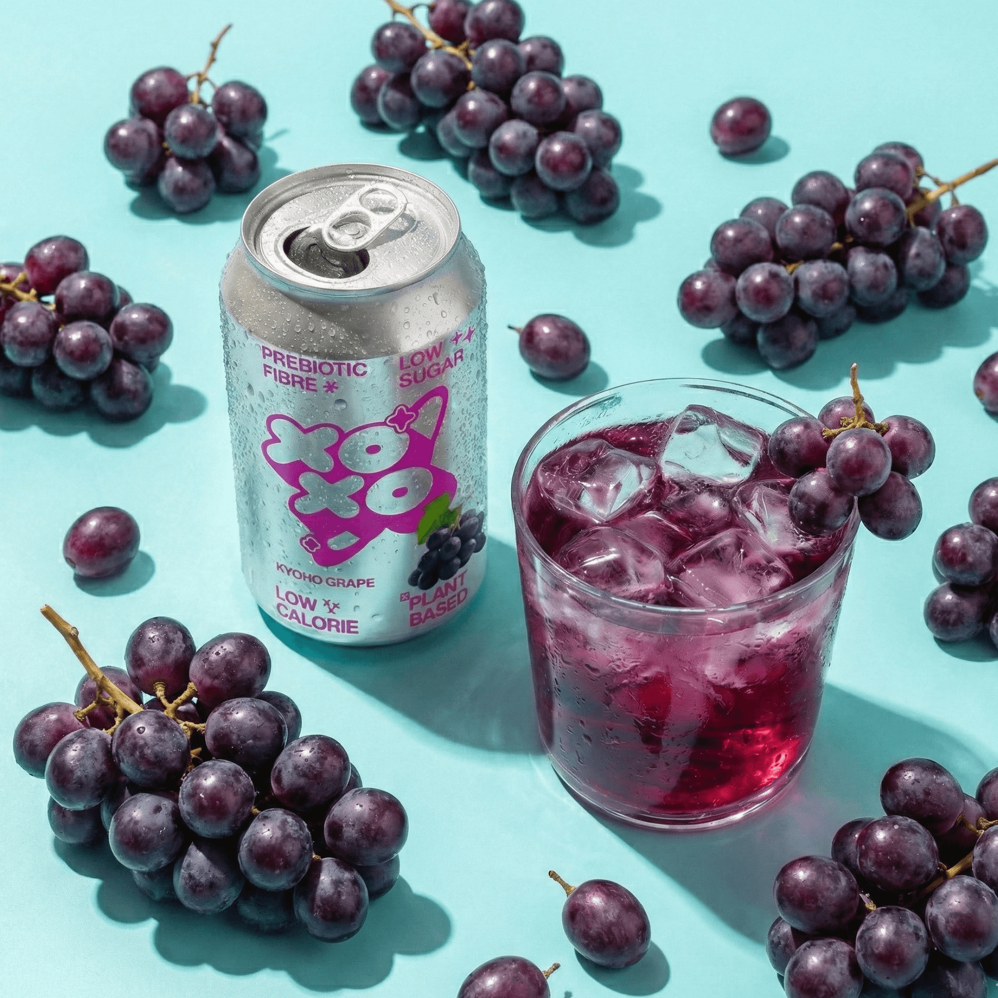 Kyoho Grape Prebiotic Soda | XOXO Limited Edition - 12 Pack with fresh grapes and ice in a glass.